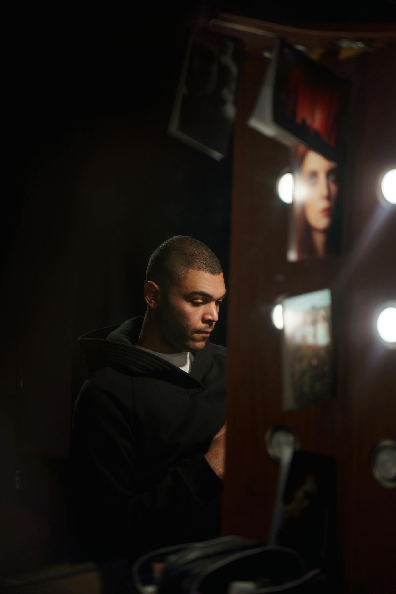 Man in Black Coat Sitting Infront Of A Mirror